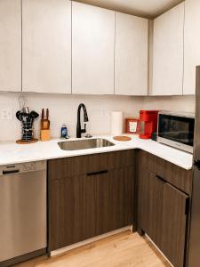 a kitchen with a sink and a microwave at Downtown Detroit Hidden Gem Walk to Venues & DMC in Detroit +12 photos