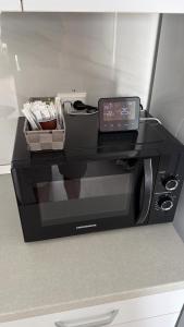 a black toaster oven with a clock on it at Apartament in Ploiesti 8 in Ploieşti