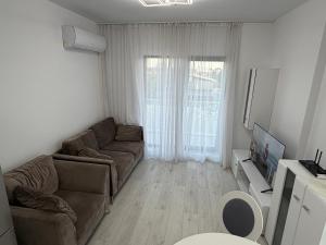 a living room with a couch and a tv at Apartament in Ploiesti 8 in Ploieşti +5 photos