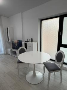a white table and chairs in a living room at Apartament in Ploiesti 8 in Ploieşti