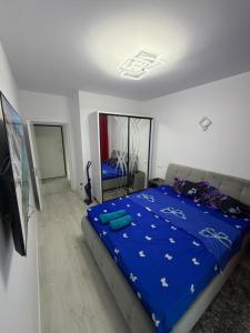 a bedroom with a bed with a blue comforter at Apartament in Ploiesti 8 in Ploieşti