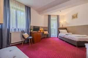 a hotel room with two beds and a desk at Casa Vlasin in Poiana Brasov