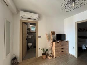 a room with a bathroom with a toilet and a television at Apartments Panda in Bol