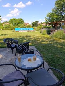 a table with a plate of food and two drinks at Mirella apartman in Palić