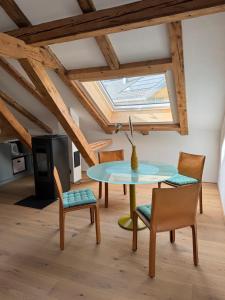 a dining room with a table and chairs and a skylight at Dachboden Loft in Laax