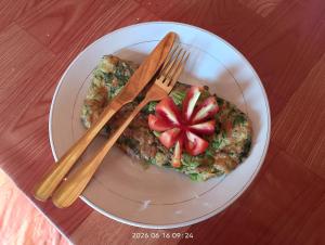 a plate with a slice of pizza with a tomato on it at Tetebatu Sunrise Homestay in Tetebatu +62 photos