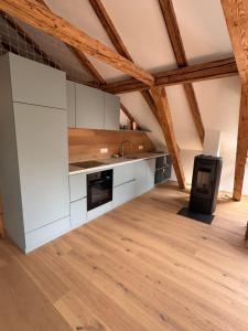 an attic kitchen with white cabinets and a sink at Dachboden Loft in Laax +14 photos