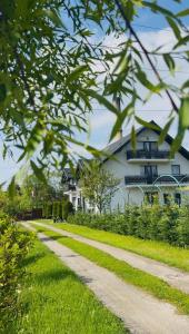 a path in the grass with a building in the background at Pensiunea Remember Me in Câmpulung