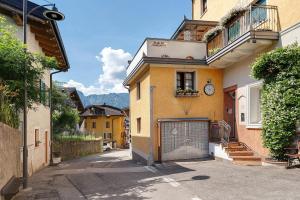 a building with a gate and a clock on it at Alla Loggia dell'Imperatore in Levico Terme