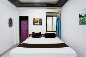 a bedroom with a large white bed in a room at Hotel O Raj Resort in Sopāra