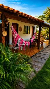 a house with a hammock on a wooden deck at Chalé Canto do Rio in Santo Amaro