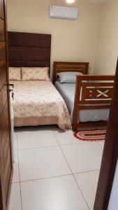 a bedroom with two beds and a tiled floor at Chalé Canto do Rio in Santo Amaro