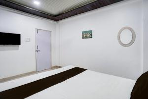 a white room with a bed and a mirror at Hotel O Raj Resort in Sopāra