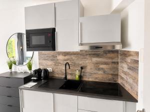 a kitchen with a sink and a microwave at Lipp Apartments in Cologne