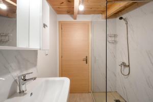 a bathroom with a sink and a glass shower door at The Three Admirals in Pylos +75 photos