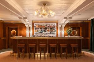 a bar with stools in a room with a chandelier at Locanda Cipriani in Torcello +12 photos