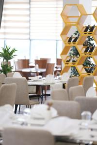 a dining room with tables and chairs and a christmas tree at Prince Adriatic Resort in Shëngjin