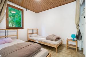 two beds in a room with a window at 7.Les rossignols option Clim-4 pers in Calviac
