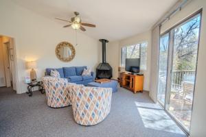a living room with a blue couch and a tv at Lakefront Bungalow with Community PoolHot Tub #1 in Lakeway