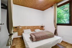 a bedroom with a bed in a room with a window at 8.Les papillons option clim-4 pers in Calviac +29 photos