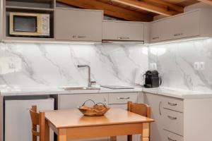 a kitchen with white counters and a wooden table at The Three Admirals in Pylos