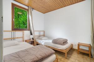 two beds in a room with a window at 6.hirondelles Option Clim- 4 pers in Calviac