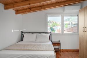 a bedroom with a bed and two windows at The Three Admirals in Pylos