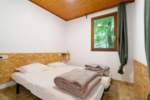 two beds in a room with a window at 15.La colline Clim.option- 6 pers in Calviac