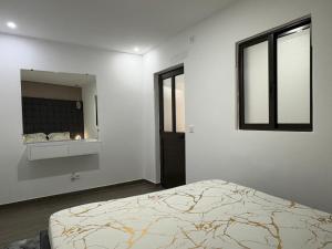 a white room with a bed and a mirror at Appart Angel in Espargos