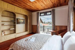 a bedroom with a bed and a large window at AT House Dalat - The Pine Concept in Da Lat