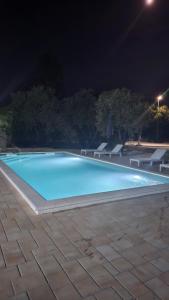 a swimming pool at night with benches around it at Villa DARIAN in Sukošan