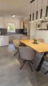 a kitchen with a wooden table and chairs at Villa DARIAN in Sukošan