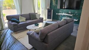 a living room with two couches and a table at Villa DARIAN in Sukošan