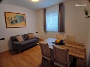a living room with a dining room table and a couch at Apartments Nadine Mljet Komfort mit Meerblick in Okuklje