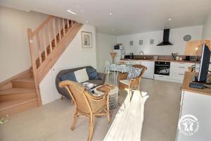 a living room with a couch and chairs and a kitchen at Les pierres d'armor in Vildé-Guingalan