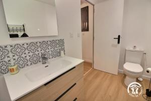 a bathroom with a white sink and a toilet at Les pierres d'armor in Vildé-Guingalan
