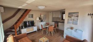 a kitchen and living room with a table and a staircase at Maxent aan zee in Middelkerke