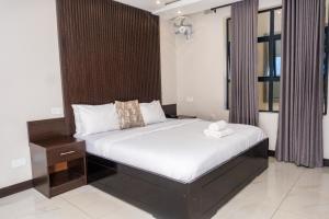 a bedroom with a bed with a wooden headboard at Purpose International Hotel Eastlea in Harare