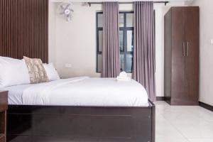 a bedroom with a large bed and a window at Purpose International Hotel Eastlea in Harare +18 photos