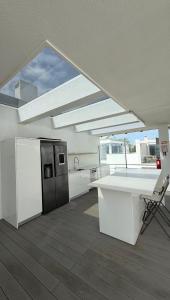a kitchen with a white counter and a refrigerator at Casa do Mar Oeiras in Oeiras