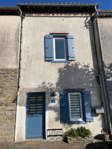 a building with blue shutters and two windows at La Bohème - Cosy, calme & confort in Saint-Papoul