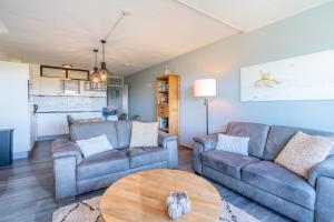 a living room with two couches and a table at Appartementencomplex Juliana 94 in De Koog