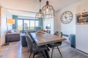 a dining room and living room with a table and chairs at Appartementencomplex Juliana 94 in De Koog