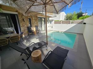 a patio with chairs and a swimming pool at Olvion Luxury Living in Kallithea Halkidikis