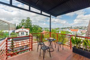 a balcony with four chairs and a table on it at AT House Dalat - The Pine Concept in Da Lat