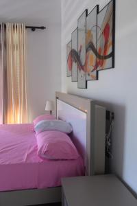 a bedroom with a purple bed with paintings on the wall at Madu Rivora Villa in Ambalangoda