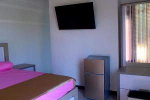 a bedroom with a bed and a television on the wall at Madu Rivora Villa in Ambalangoda