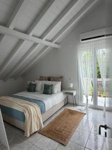 a white bedroom with a large bed and a window at Angel Apartment in Fiskardo