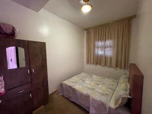 a small bedroom with a bed and a dresser at maison souk agadir in Agadir
