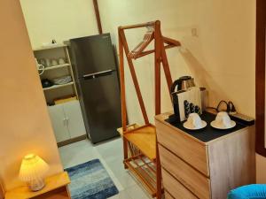 a kitchen with a refrigerator and a table with shoes at Blue Cottage Koh Kood a Quiet Tropical Getaway in Ban Lak Uan